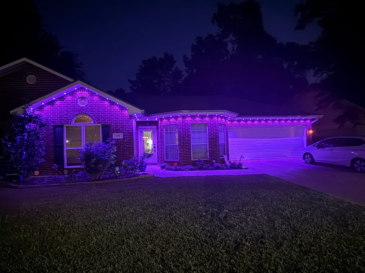 Brick ranch home at night lit in solid purple