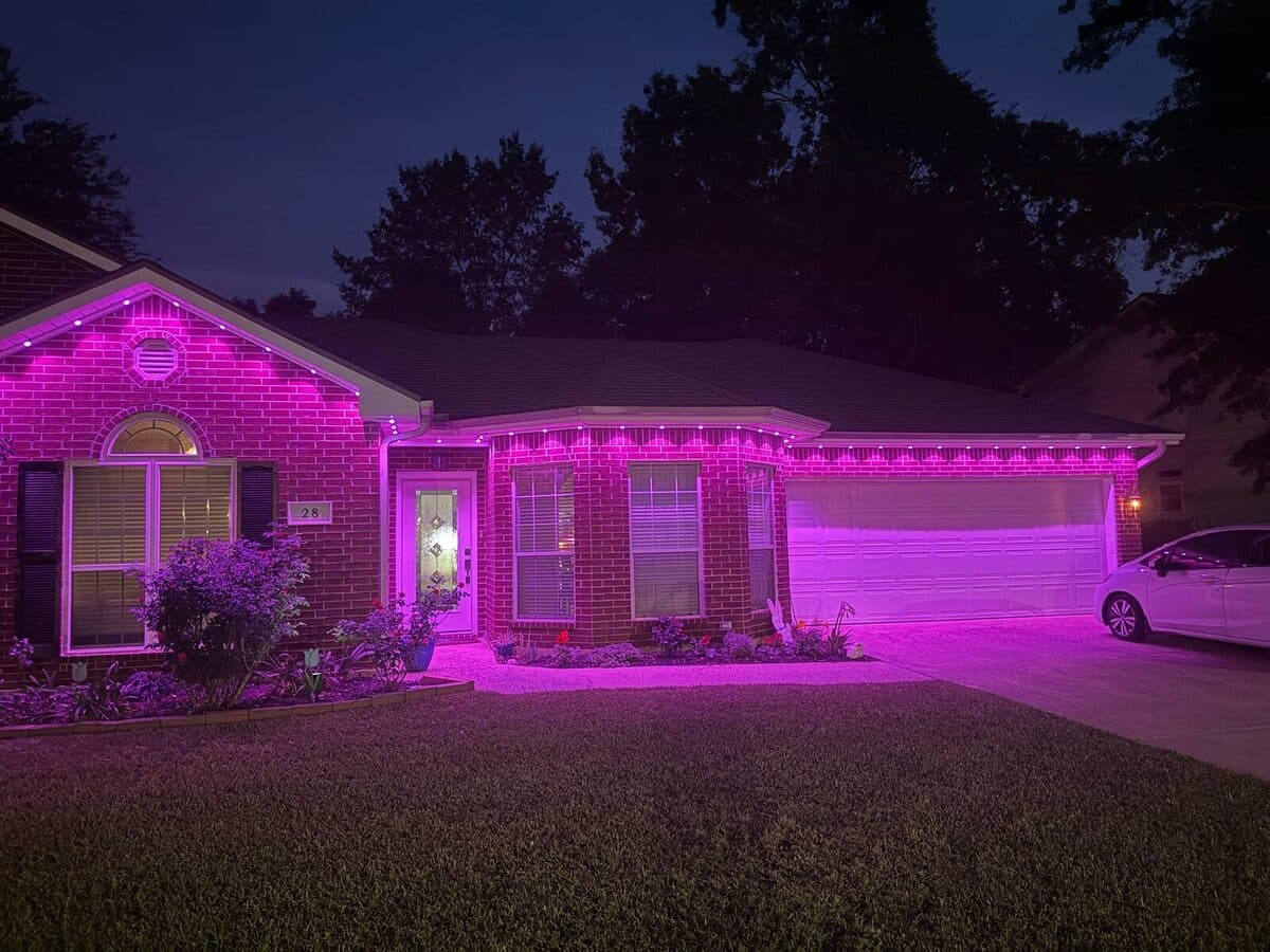 Brick ranch home at dusk lit in solid pink