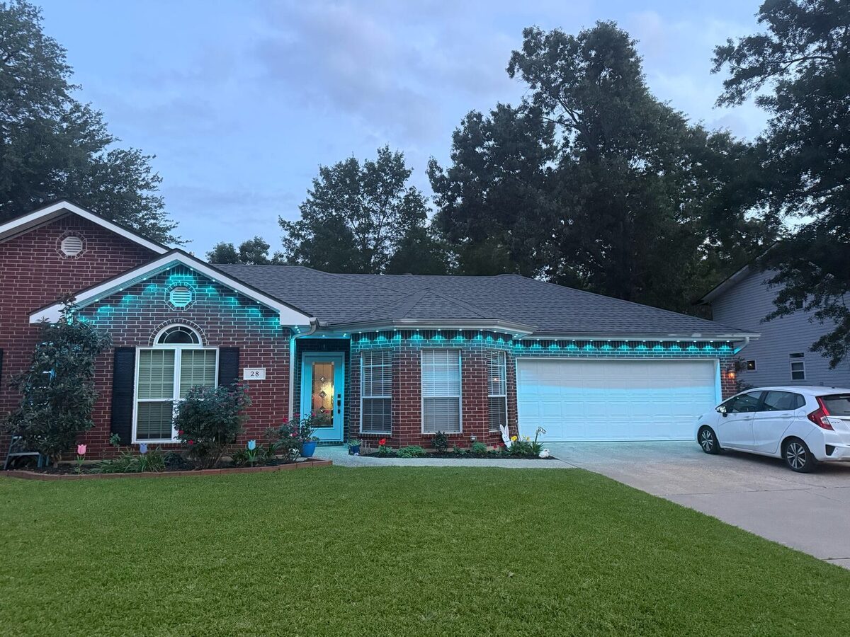 Brick ranch home in daylight with GeauxTrax tracks installed along the roofline, showing how the channel is nearly invisible during the day