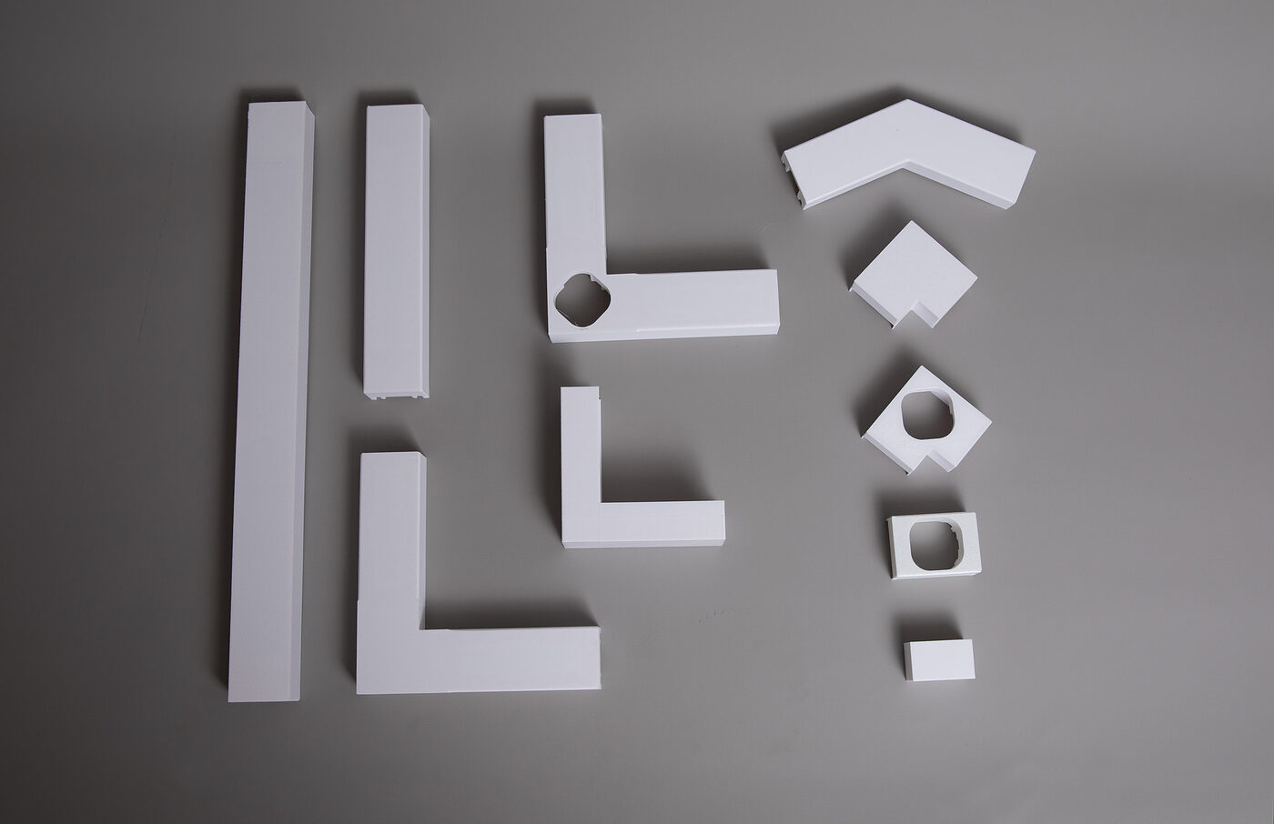 All GeauxTrax components laid out: base tracks, corners, light holders, end caps, spacers