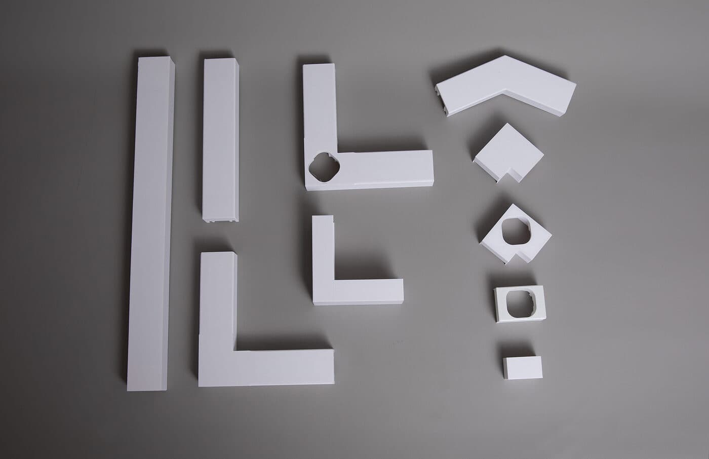 All GeauxTrax components laid out: base tracks, corners, light holders, end caps, spacers